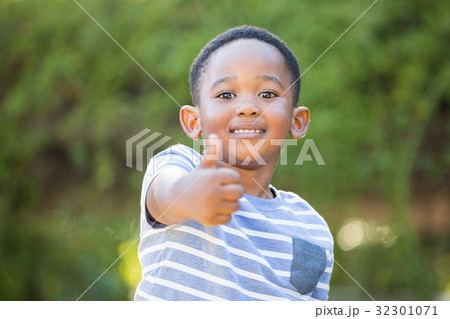 Portrait of cute boy smiling with thumbs up 32301071