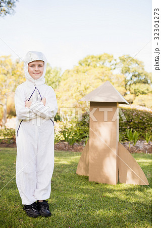 Cute boy with astronaut dress posing next to his cardboard rocket Cute boy with astronaut dress posing next to his cardboard rocket 32301273