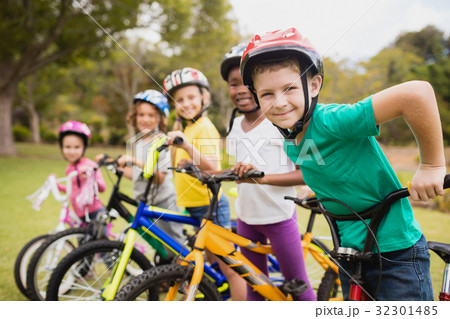 Children wearing helmet and posing on their bike 32301485