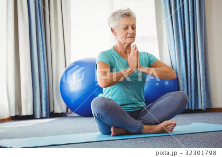 Portrait of senior woman sitting in lotus position 32301798