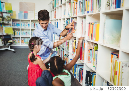 Kids selecting a book to read Kids selecting a book to read 32302300