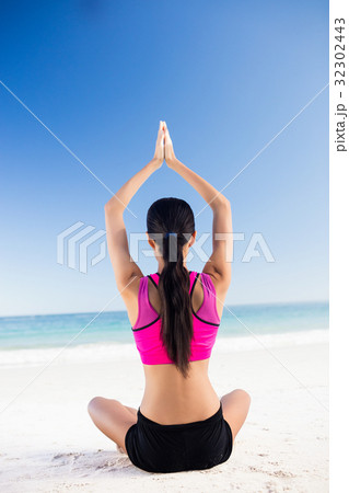 Woman doing yoga on the beach 32302443