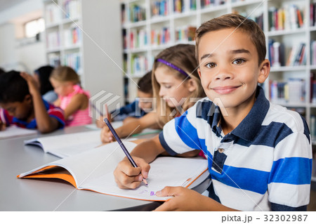 Little boy posing for the camera while he is coloring 32302987