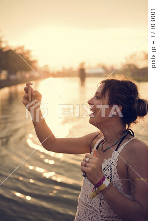 Caucasian woman taking photo sunset Caucasian woman taking photo sunset 32303001
