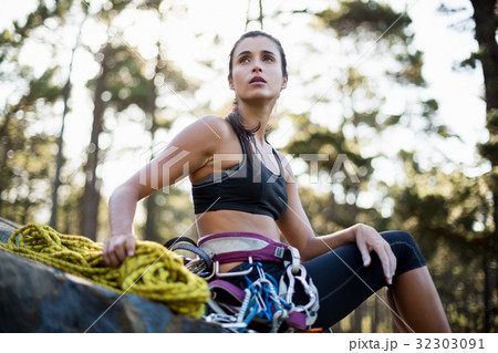Woman sitting with climbing equipment Woman sitting with climbing equipment 32303091