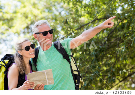 Couple pointing and holding a map 32303339