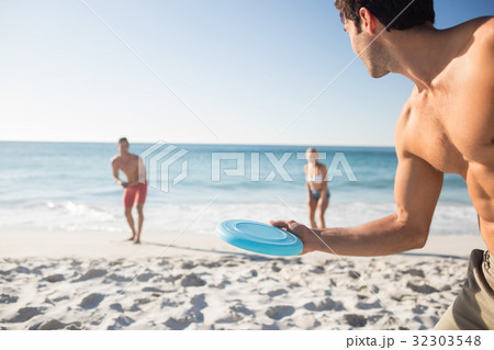 Friends playing with a frisbee 32303548