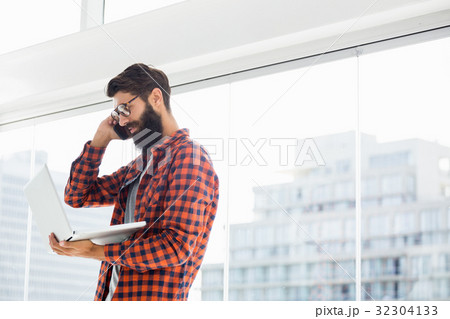 Hipster using phone and laptop Hipster using phone and laptop 32304133