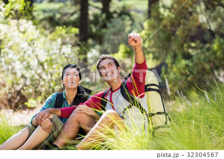 Couple sitting and pointing Couple sitting and pointing 32304567