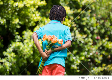A kid hiding bouquet behind back A kid hiding bouquet behind back 32304804