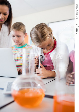 Pupil looking through a microscope 32305768