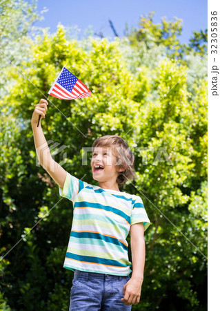 A little boy is holding an american flag 32305836
