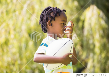 Child is using an asthma inhaler 32306435