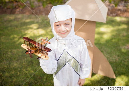Portrait of cute boy with astronaut dress holding a little plane Portrait of cute boy with astronaut dress holding a little plane 32307544