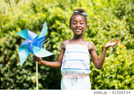 Cute mixed-race girl smiling and holding a windmill Cute mixed-race girl smiling and holding a windmill 32308134