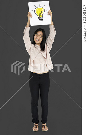Young adult asian girl smiling and holding light bulb banner Young adult asian girl smiling and holding light bulb banner 32308317