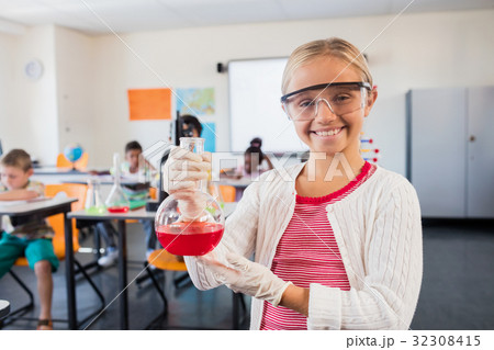 A pupil smiling at the camera with beaker A pupil smiling at the camera with beaker 32308415