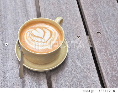 Cup of coffee on the wooden table with latte art. 32311210
