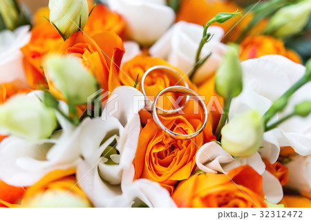 Pair of golden wedding rings inside bridal bouquet 32312472