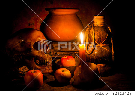 Skull and candle with candlelight on wooden 32313425