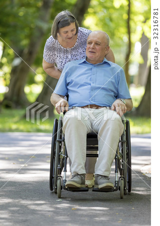 Senior woman pushing husband in wheelchair 32316781
