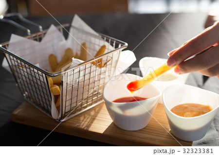 French fries in a metal basket with sauce 32323381