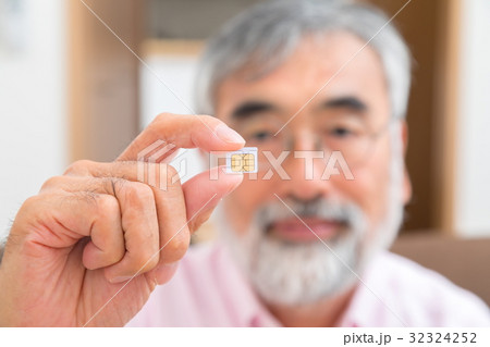 シムカードを持つシニア世代の男性の手元　シニア　ポートレート　50代　60代 32324252