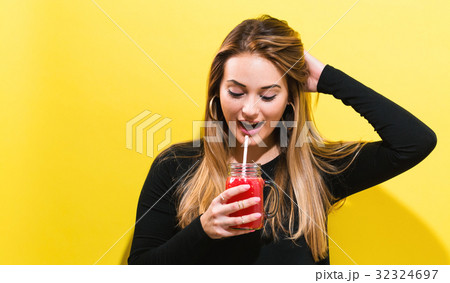 Happy young woman drinking smoothie Happy young woman drinking smoothie 32324697