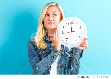 Woman holding clock showing nearly 12 Woman holding clock showing nearly 12 32324786