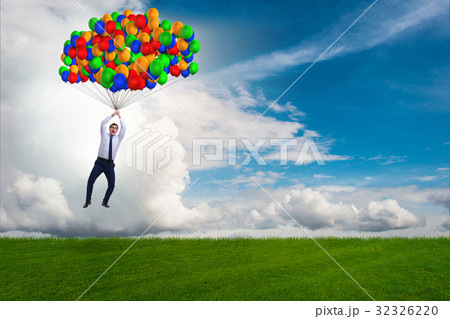 Businessman flying balloons on bright day Businessman flying balloons on bright day 32326220