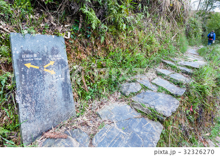 tourist near road sign to Tiantou village 32326270