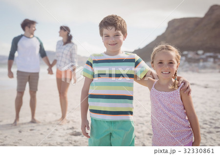 Portrait of smiling siblings with parents standing in backgeround 32330861