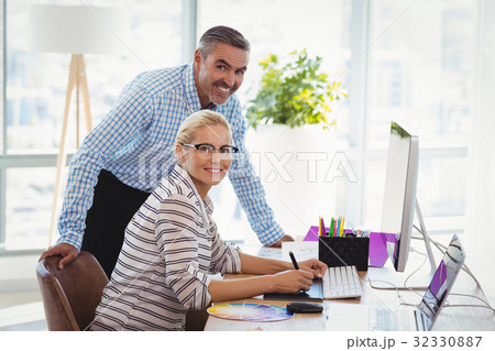 Portrait of smiling graphic designers working at desk Portrait of smiling graphic designers working at desk 32330887