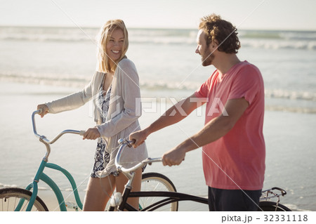 Happy young couple with bicycles at beach Happy young couple with bicycles at beach 32331118