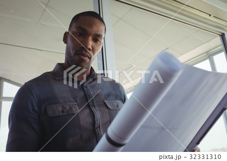 Interior designer reading blueprint in office 32331310
