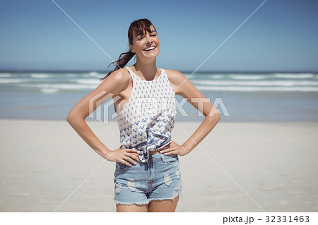 Portrait of smiling woman standing at beach 32331463