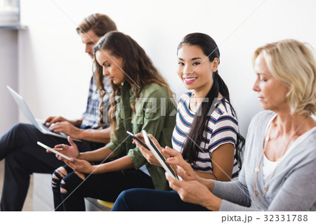 Portrait of businesswoman sitting by colleagues 32331788