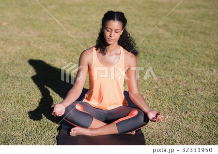 Woman practicing lotus position on mat 32331950