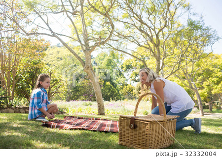 Mother and daughter spreading the picnic blanket Mother and daughter spreading the picnic blanket 32332004