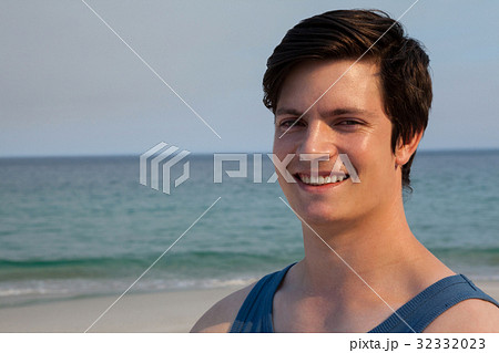 Smiling man standing at beach on a sunny day 32332023