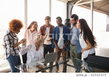Happy businesswoman with coworkers at creative office 32332375
