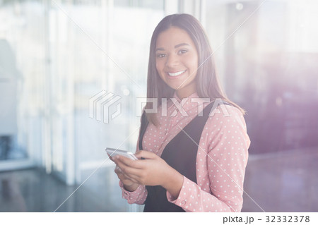 Portrait of smiling businesswoman using mobile 32332378
