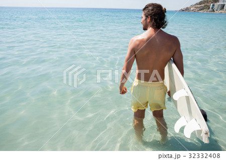 Surfer with surfboard looking at sea 32332408