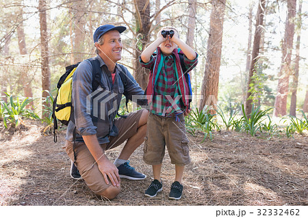 Happy man watching boy looking through binoculars Happy man watching boy looking through binoculars 32332462