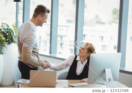 Smiling executives shaking hands 32332566