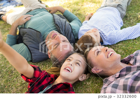 Happy family lying on the grass 32332600