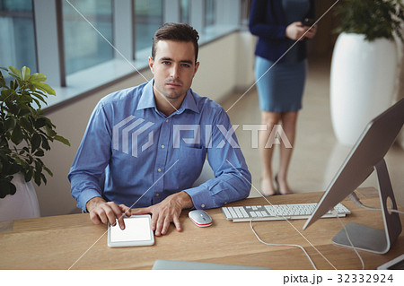 Portrait of executive using digital tablet at desk Portrait of executive using digital tablet at desk 32332924