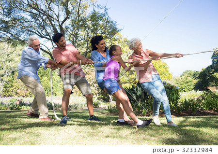 Family playing tug of war in the park 32332984