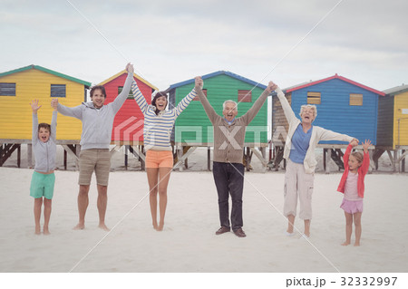Portrait of cheerful multi-generation family holding hands at beach 32332997