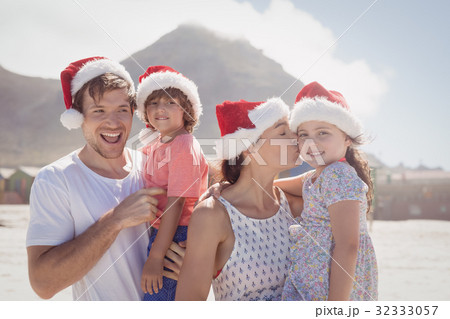 Cheerful family wearing Santa hat at beach Cheerful family wearing Santa hat at beach 32333057